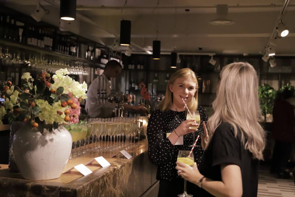 Event attendees mingle and network at the bar