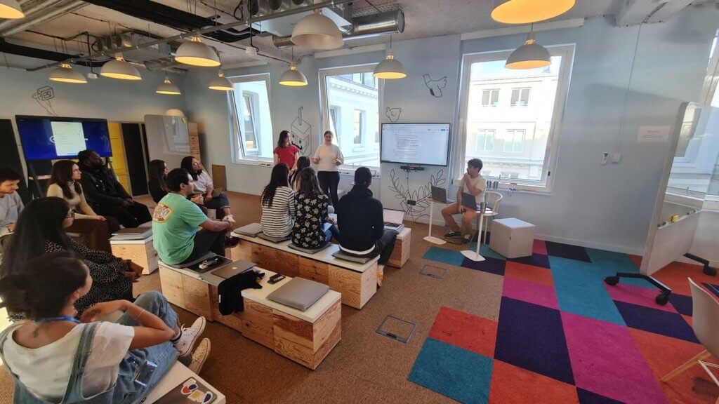 Image of multiple people sitting together with two people giving a lecture